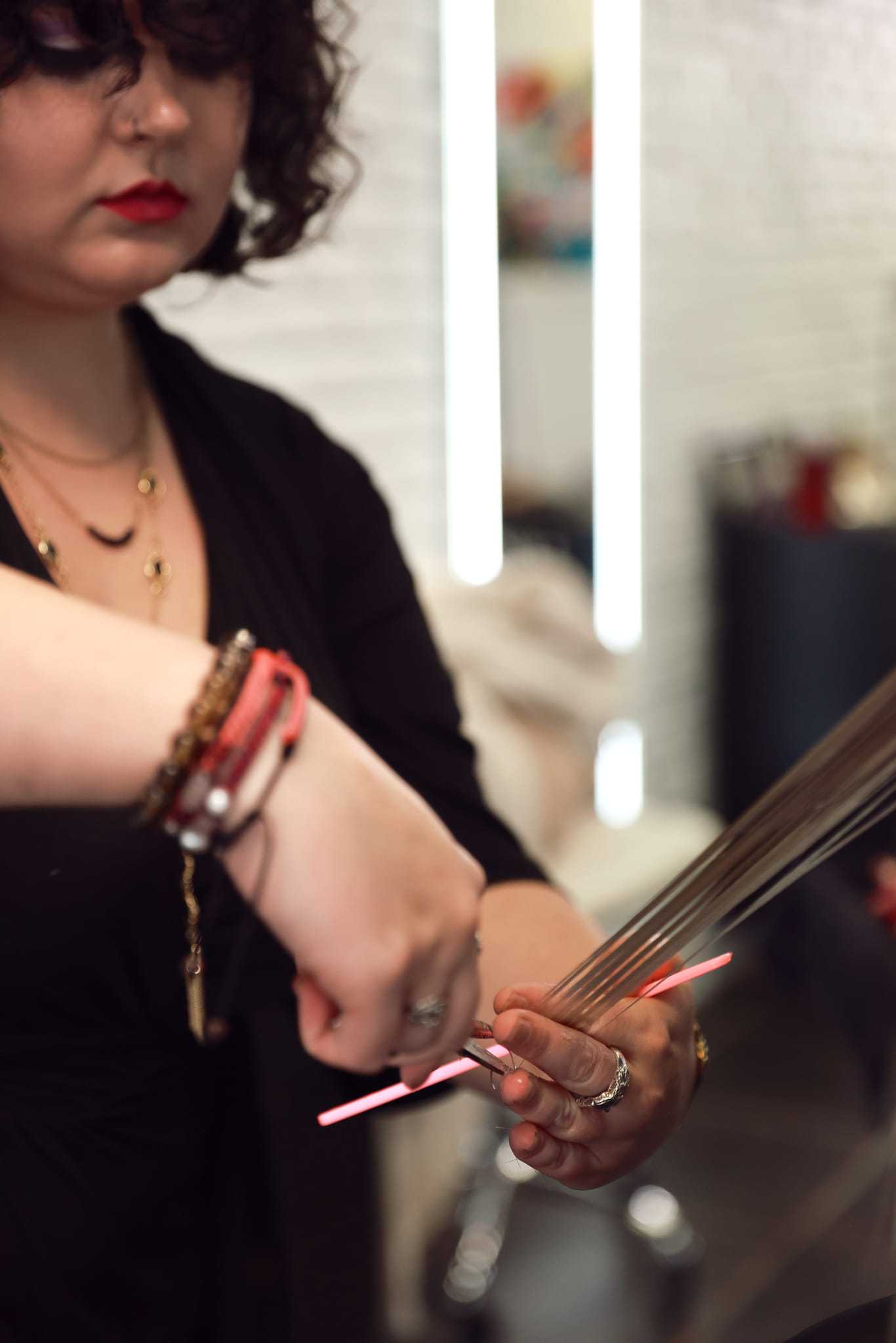 Hair stylist cutting strands in salon setting with focused attention.